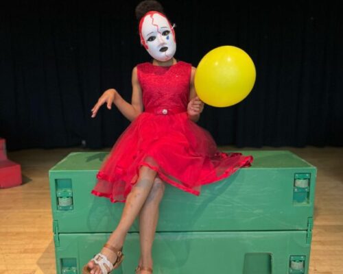 Young performer balancing a ball during a stage exercise in an acting workshop for kids in Miami.